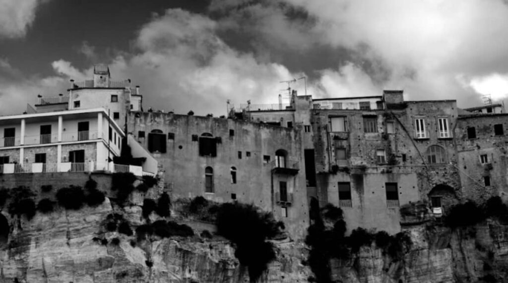 Scorcio di Tropea affacciato sul mare cristallino della Costa degli Dei, con le sue casette colorate arroccate sulla scogliera, perfetto per un investimento in una località balneare di rara bellezza