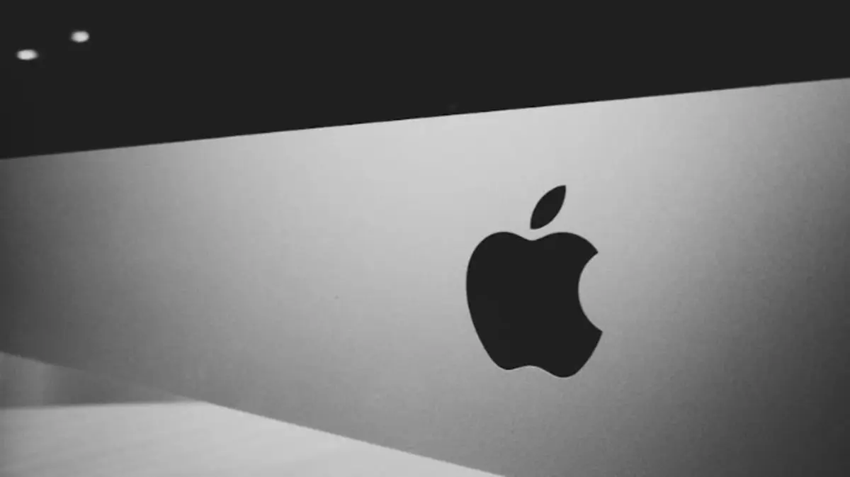 Un primo piano iconico del logo Apple illuminato sul retro di un MacBook Pro, simbolo di innovazione e design