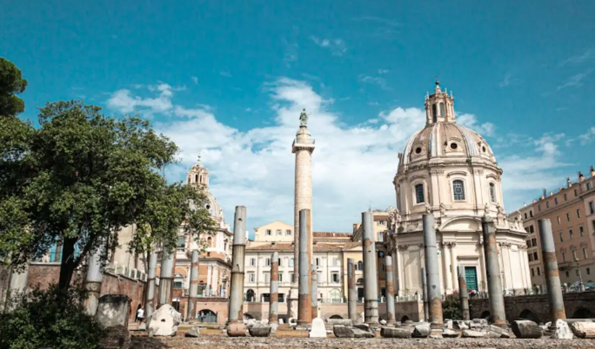 Veduta delle antiche rovine del Foro Romano a Roma sotto un cielo azzurro, simbolo di una meta turistica classica in Italia.