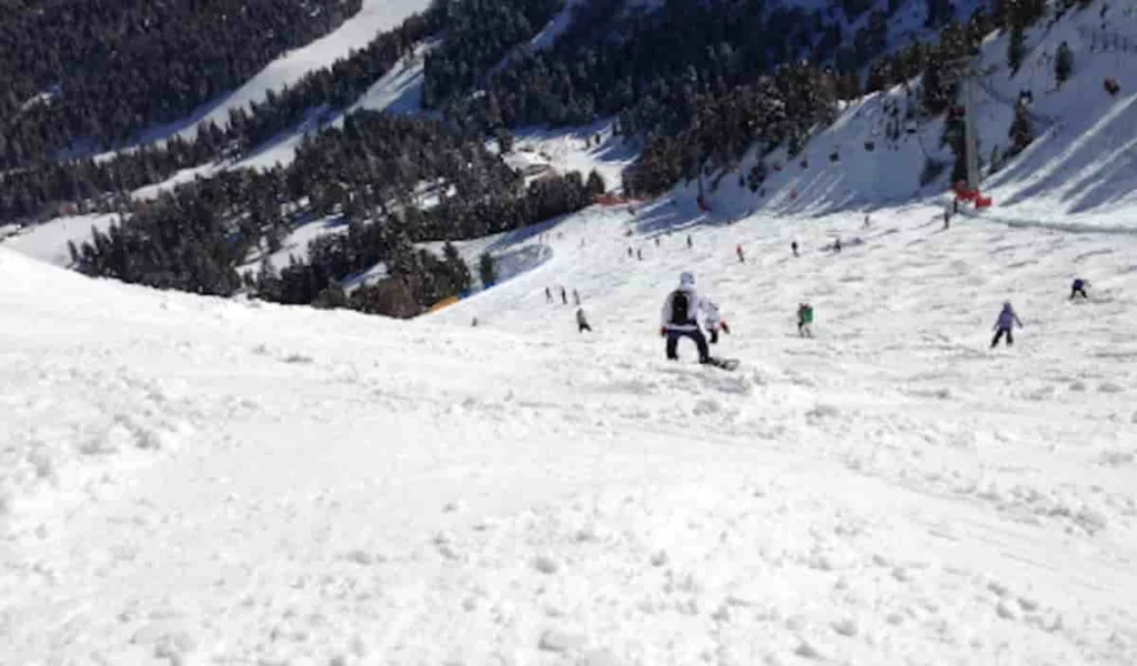 Sciatore esperto che scende velocemente in pista, rappresentazione della responsabilità civile verso terzi nello sci.
