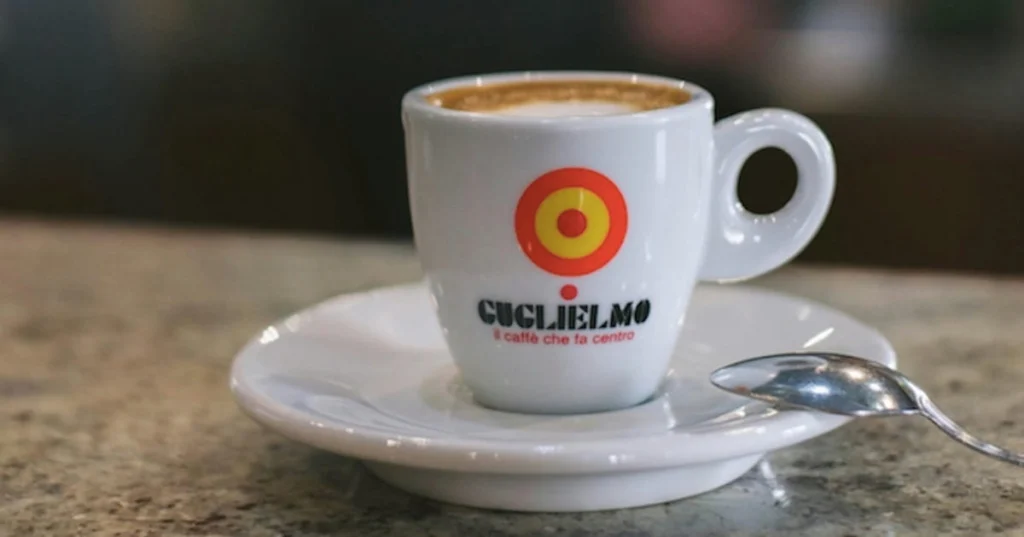 Tazza di caffè caldo su tavolo in legno collegata al tema degli investimenti sul caffè in Borsa