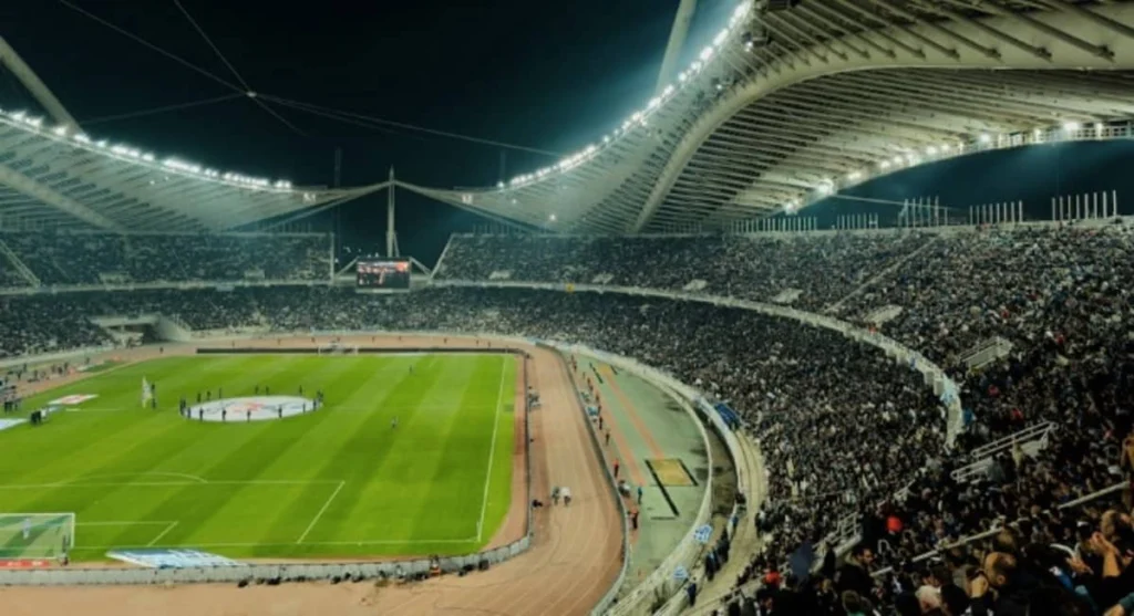 Veduta panoramica di uno stadio calcistico gremito di tifosi durante una partita importante