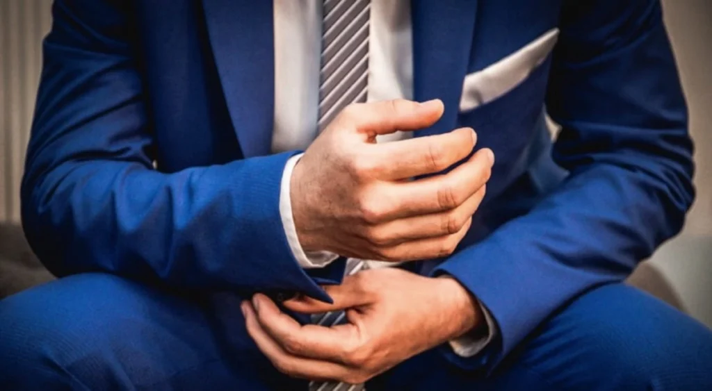 Primo piano ravvicinato del busto di un manager in giacca scura e cravatta, simbolo degli analisti istituzionali di Wall Street.