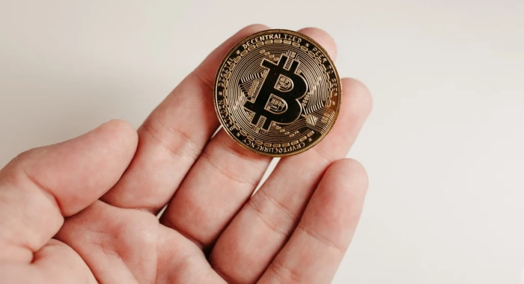 Una persona con un Bitcoin in mano