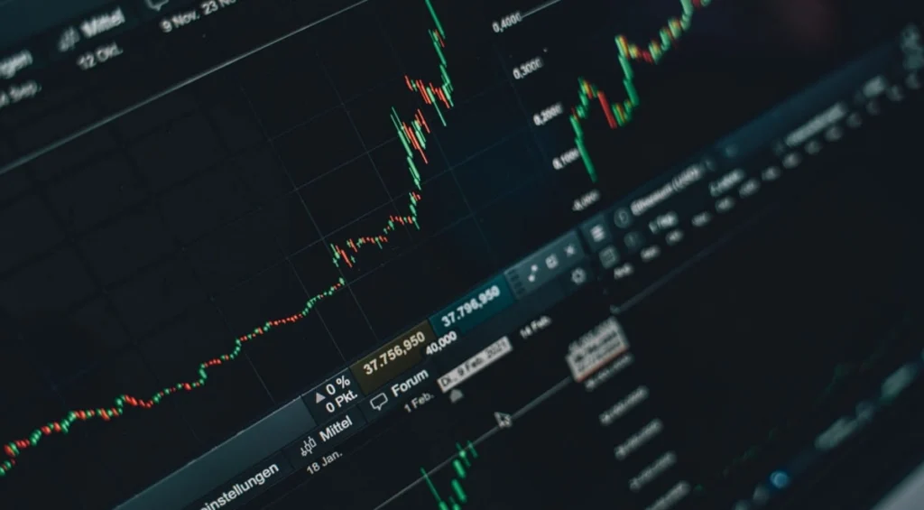 Analista finanziario al computer mentre esamina l'andamento dei titoli e le metriche di rischio