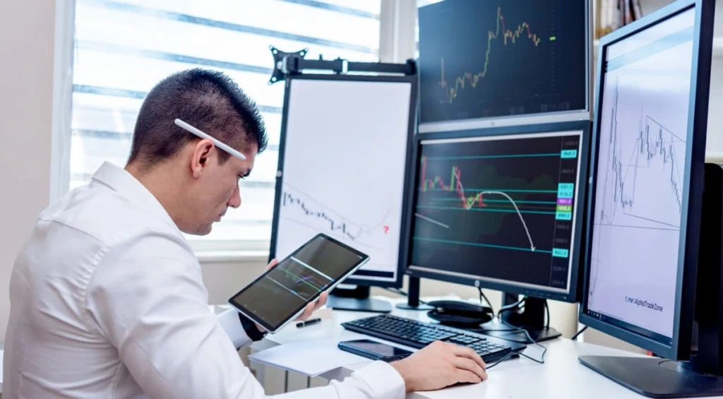 Trader professionista analizza i grafici di borsa per valutare la volatilità e i movimenti di prezzo sui mercati
